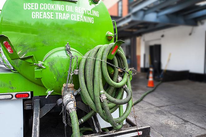 a grease trap being pumped by a sanitation technician in Oakland CA